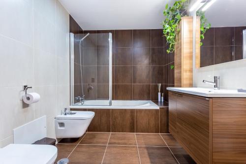 Un baño con bañera, inodoro y lavabo. en Casa Chic, en Vila do Bispo