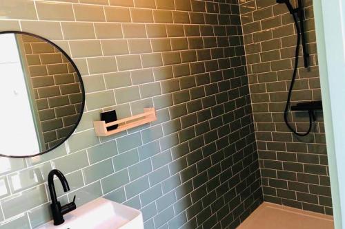 een badkamer met een wastafel en een spiegel bij De slaaploods in Kerkrade