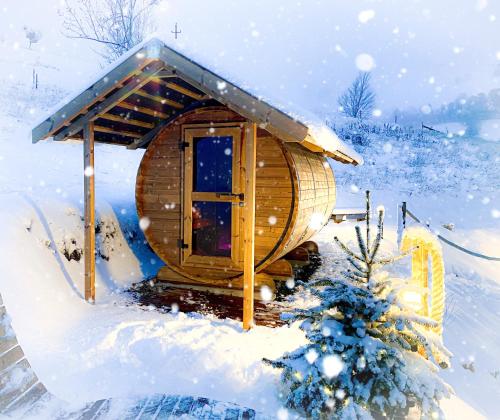 eine Holzhütte im Schnee mit einem Weihnachtsbaum in der Unterkunft Lieblingsort - Cosy Black Forest Chalets in Neuenweg