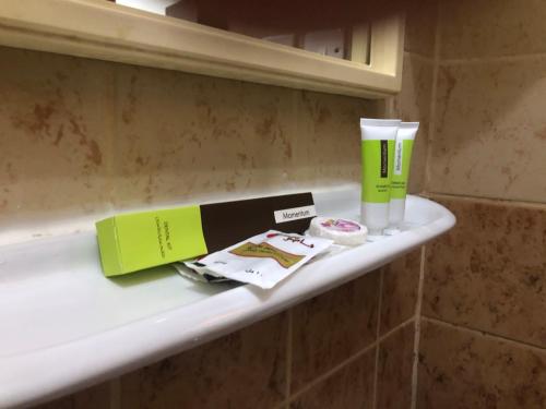 estante en el baño con botella y taza en رايتنا للوحدات السكنية المفروشة, en Riad