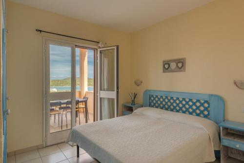 ein Schlafzimmer mit Bett und Blick auf das Meer in der Unterkunft Baia de Bahas Residence in Golfo Aranci
