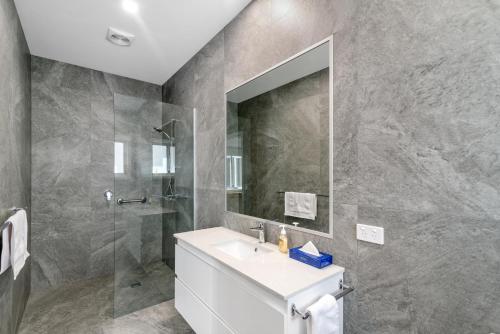 a bathroom with a sink and a shower and a mirror at Black Dolphin Waterfront Apartment in San Remo