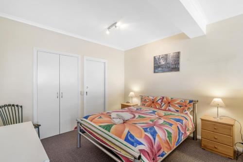 a bedroom with a bed with a colorful bedspread at Black Dolphin Waterfront Apartment in San Remo