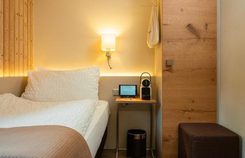 a hotel room with a bed and a laptop on a desk at Hotel Landhaus in Münster