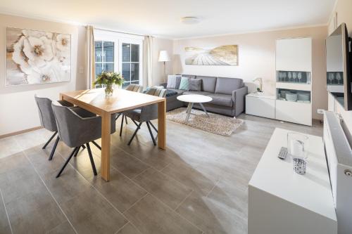 a living room and dining room with a table and a couch at Winkelschiffchen II mit Sauna in Juist