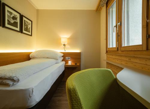 a bedroom with a bed and a window and a chair at Hotel Landhaus in Münster