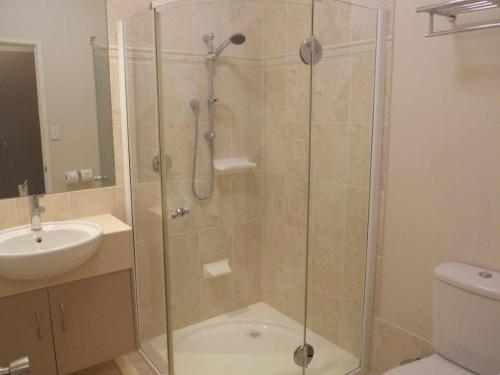 a shower with a glass door in a bathroom at Emerald Executive Apartments in Emerald