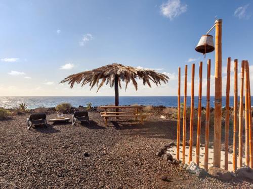 a fence on a beach with a tree and the ocean at Holiday Home Los Jablitos by Interhome in Las Indias