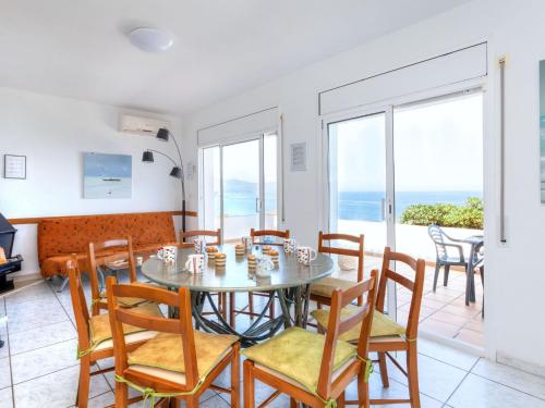 una sala da pranzo con tavolo, sedie e vista sull'oceano di Holiday Home Don Quijote by Interhome a Llança
