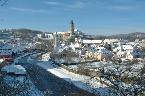 a city with snow covered buildings and a town at Hotel Latrán in Český Krumlov