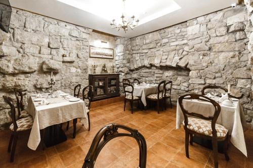 a restaurant with two tables and a stone wall at Apart-hotel Horowitz in Lviv