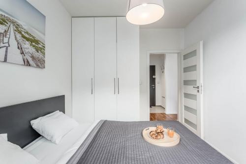 a bedroom with a bed with a plate on the floor at Chill Apartments Airport Residence in Warsaw