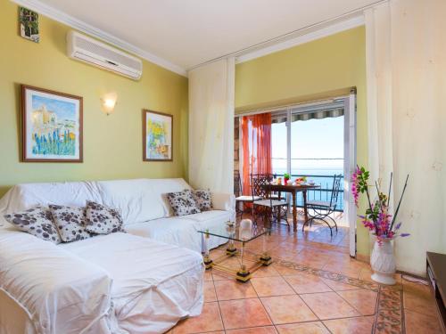 a living room with a white couch and a table at Holiday Home Mila i Fontanals by Interhome in Roses