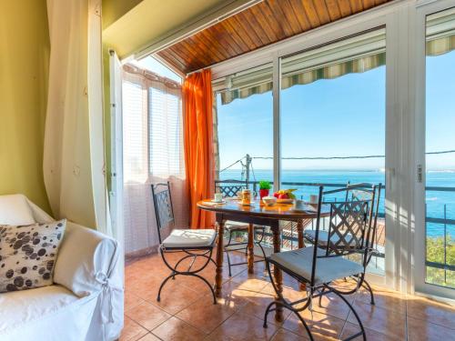 a living room with a table and chairs and a view of the ocean at Holiday Home Mila i Fontanals by Interhome in Roses