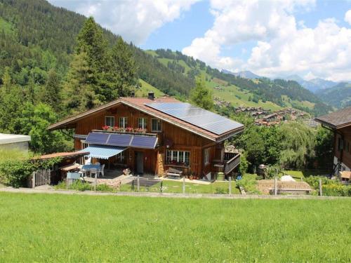 a house with a solar roof on a green field at Apartment Burkhalter by Interhome in Zweisimmen