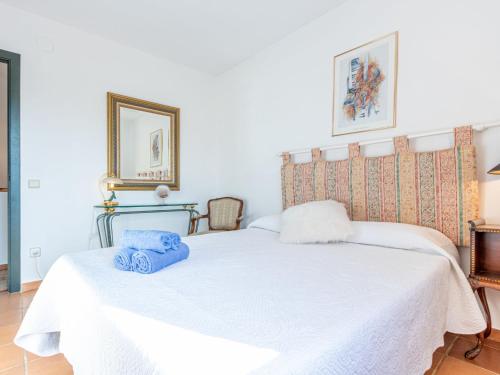 a bedroom with a white bed with blue towels on it at Holiday Home acacies by Interhome in Navata