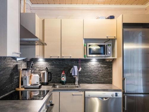 a kitchen with a stainless steel refrigerator and a microwave at Holiday Home Leimu a by Interhome in Vuokatti