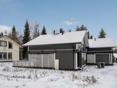 a house is covered in snow in front of a house at Holiday Home Leimu a by Interhome in Vuokatti