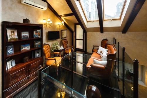 uma sala de estar com cadeiras e um corrimão de vidro em Apart-hotel Horowitz em Lviv