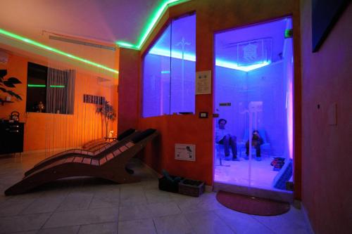a room with a person sitting in a room with purple lights at Hotel Relais Valle Orientina in Pitigliano