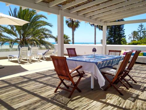 a table and chairs on a patio with the ocean at Holiday Home Los Frasquitos by Interhome in Vera