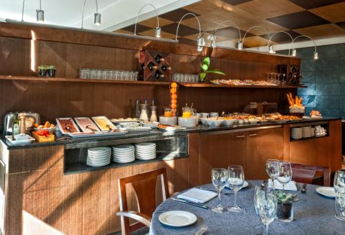 a restaurant with a table and a buffet of food at Best Western Plus Hotel Alfa Aeropuerto in Barcelona