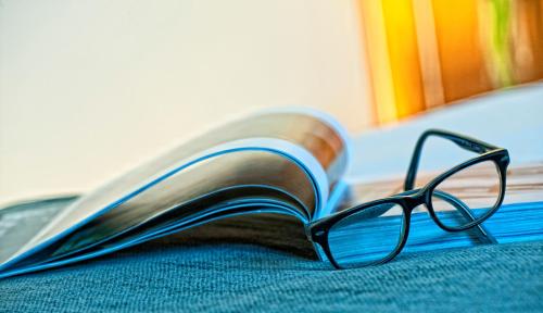 a pair of glasses laying on top of a book at Best Western Plus Hotel Alfa Aeropuerto in Barcelona