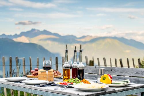 a table with plates of food and wine on it at Chalet Stern in Vipiteno
