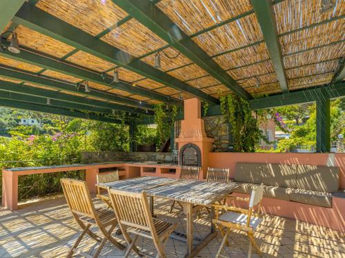 patio ze stołem i krzesłami pod pergolą w obiekcie Villa Aldo by Interhome w Rapallo