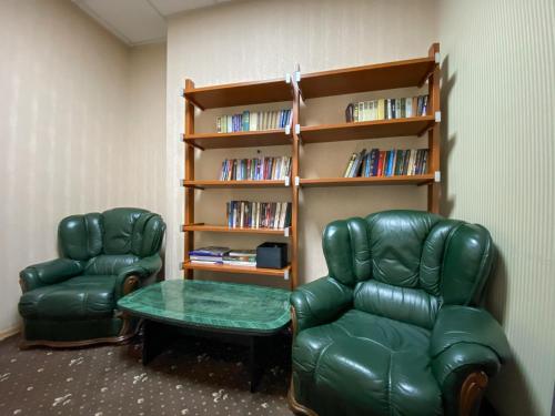 a room with two chairs and a table and a book shelf at irisHotels in Kyiv