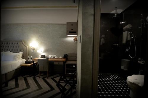 a bedroom with a bed and a desk and a bed and a room with at 1969 Business Suites @ Ipoh Garden in Ipoh
