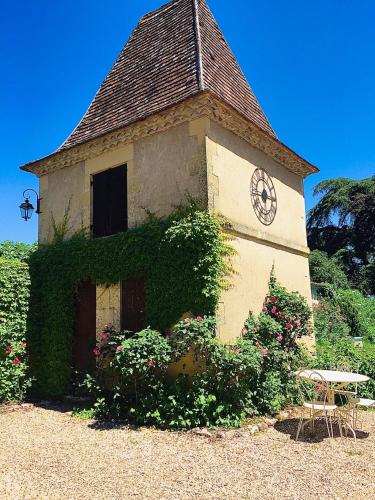 a building with a clock on the side of it at Manoir du Bois Mignon in Le Fleix