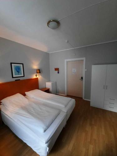 a bedroom with a large white bed in it at Sunndalsøra Hotell in Sunndalsøra