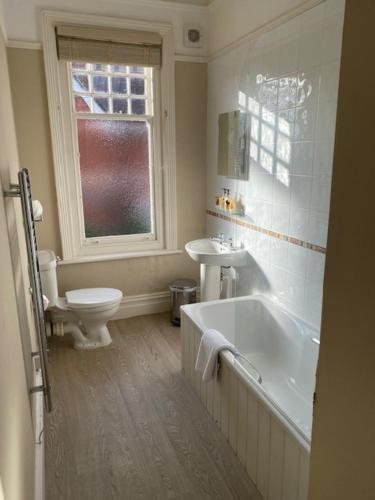 a bathroom with a tub and a toilet and a sink at Inn in the Park in Bournemouth
