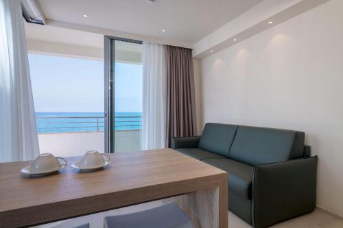a room with a table and a chair and a window at Palace Lido Hotel & Suites in Marina di Cecina