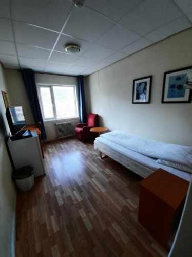 a bedroom with a bed and a wooden floor at Sunndalsøra Hotell in Sunndalsøra