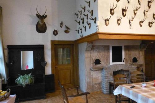 a living room with a fireplace and antlers on the wall at Landhaus Holthausen in Werne an der Lippe
