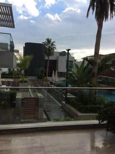 a view of a resort with a pool and palm trees at Carmencita Studio B14 with pool & gym in Limassol