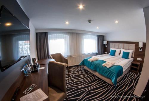 ein Hotelzimmer mit einem großen Bett und einem Schreibtisch in der Unterkunft No1 bed&breakfast lounge in Leszno
