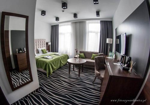 Habitación de hotel con cama y espejo en No1 bed&breakfast lounge en Leszno