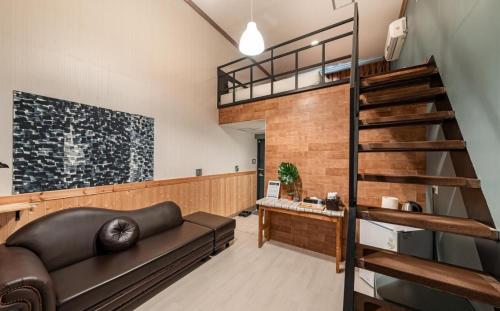 een woonkamer met een bank en een loft bij Hotel Hue Loft in Incheon