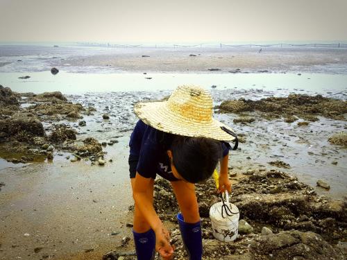 a woman in a straw hat standing on the beach at Hotel Hue Loft in Incheon