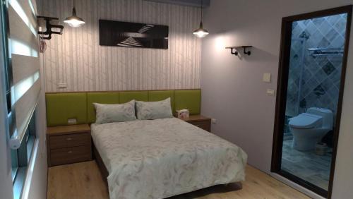 a small bedroom with a bed and a toilet at Host Garden悠禾園 in Hualien City