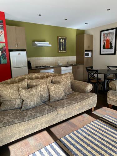 a living room with a couch and a kitchen at Adelphi Apartment 4 in Echuca