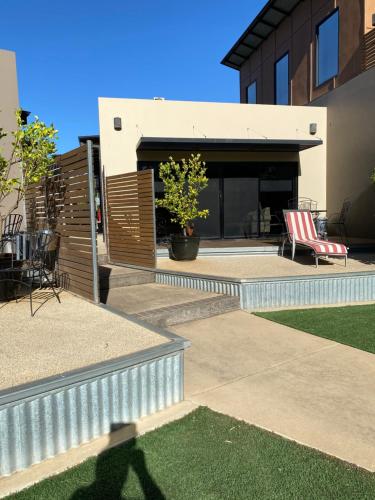 Blick auf ein Haus mit einer Terrasse mit einem roten Stuhl in der Unterkunft Adelphi Apartment 4 in Echuca