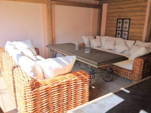 a living room with a table and wicker chairs at Apartmán Praha Břevnov in Prague