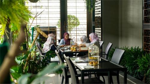 a group of people sitting at a table in a restaurant at 1969 Business Suites @ Ipoh Garden in Ipoh