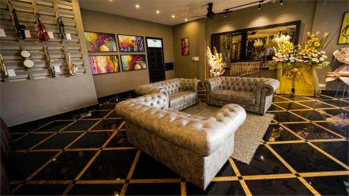 a living room with couches and chairs in a room at 1969 Business Suites @ Ipoh Garden in Ipoh