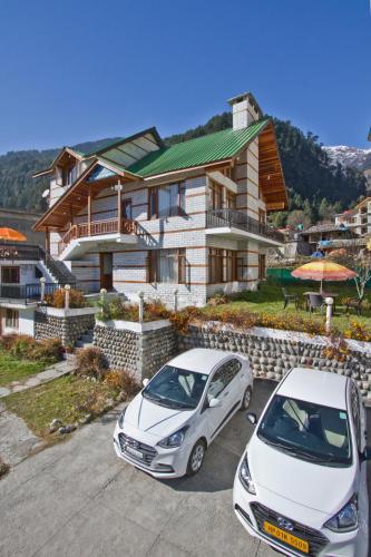 two cars parked in a parking lot in front of a house at THE CEDAR VILLA AND APARTMENT,Bonefire,Cook,Helper,Kitchen,Lawn,Parking,5 min Drive Mall road in Manāli