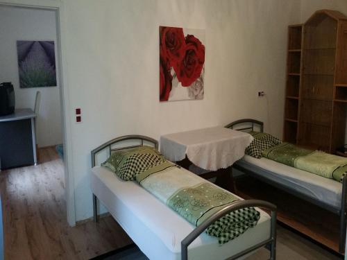Cette chambre comprend 2 lits et une table. dans l'établissement Gästehaus 22 - Appartementhaus, à Baden-Baden